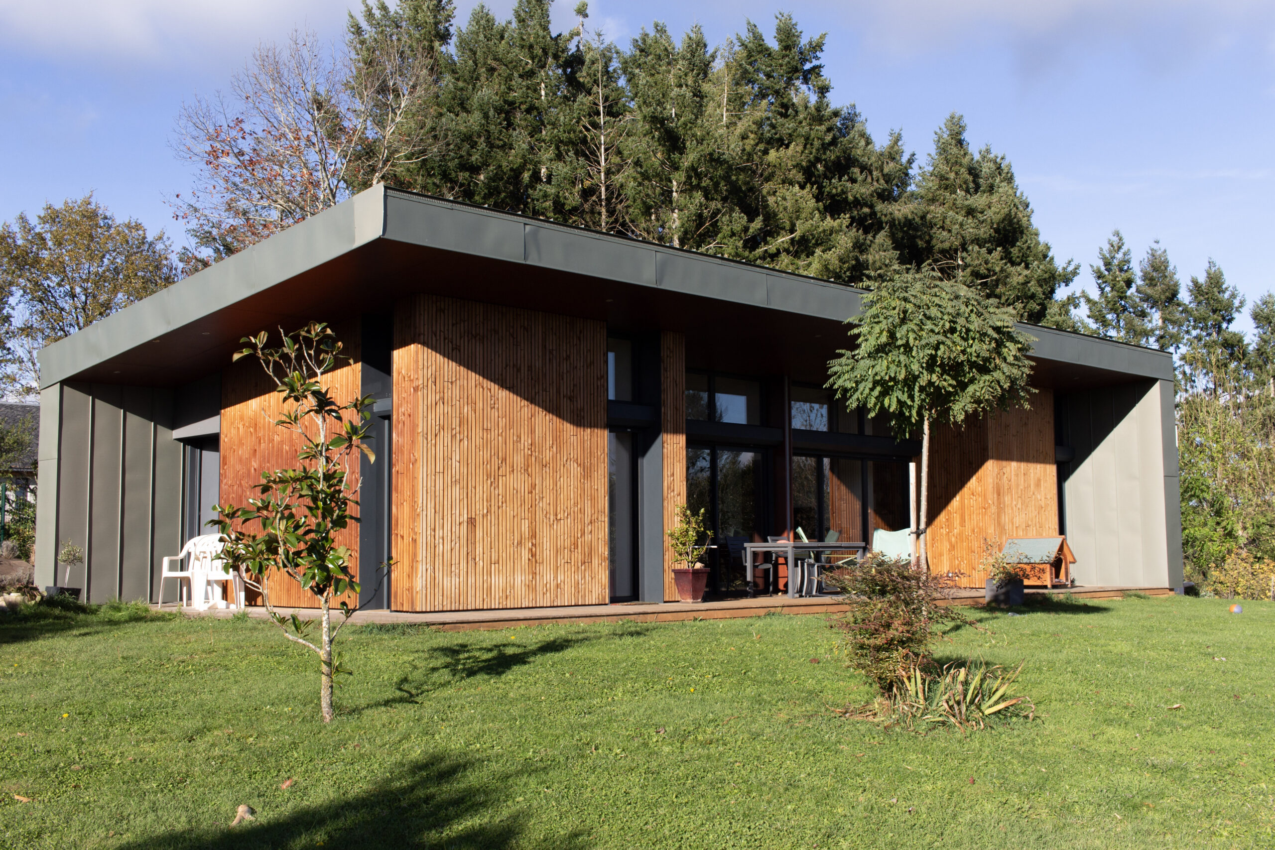 L'image représente une maison d'architecte réalisée par l'agence Droit de cité. Les matériaux principalement utilisés en extérieur sont le bois et le zinc.