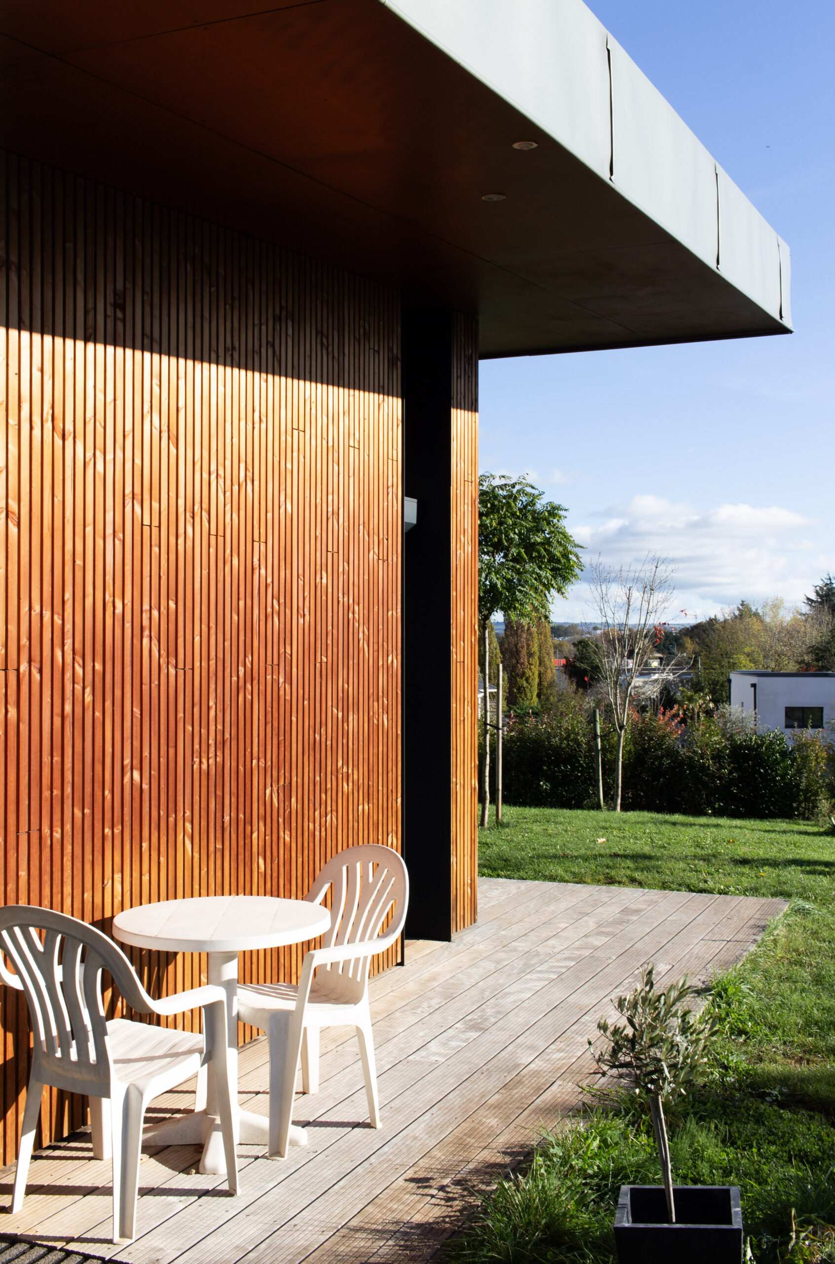 Bardage bois et toiture zinc pour une intégration réussie de cette maison d'architecte dans son environnement.